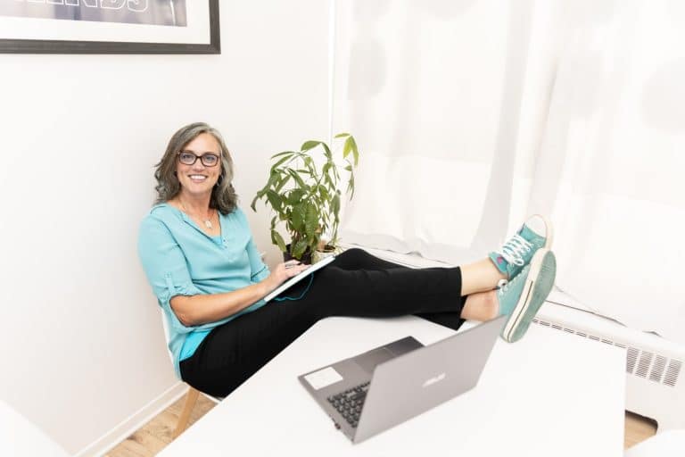 Steph Walker working on a laptop with her feet up in a bright office